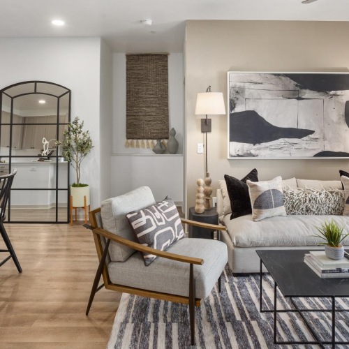 a living room with a large painting and various seating