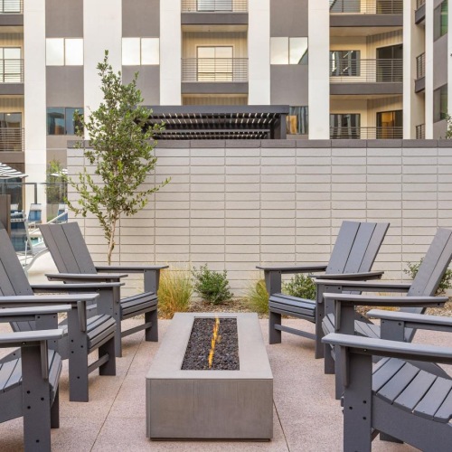 a courtyard with a firepit and chairs