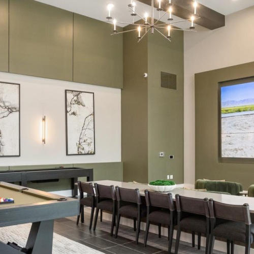 a lounge room with a pool table and chairs and tv